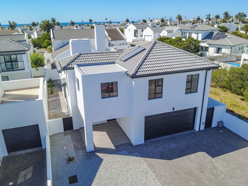 Aerial view of a modern two-story residential property featuring a tiled roof, solar panels, and a paved driveway with a double garage.