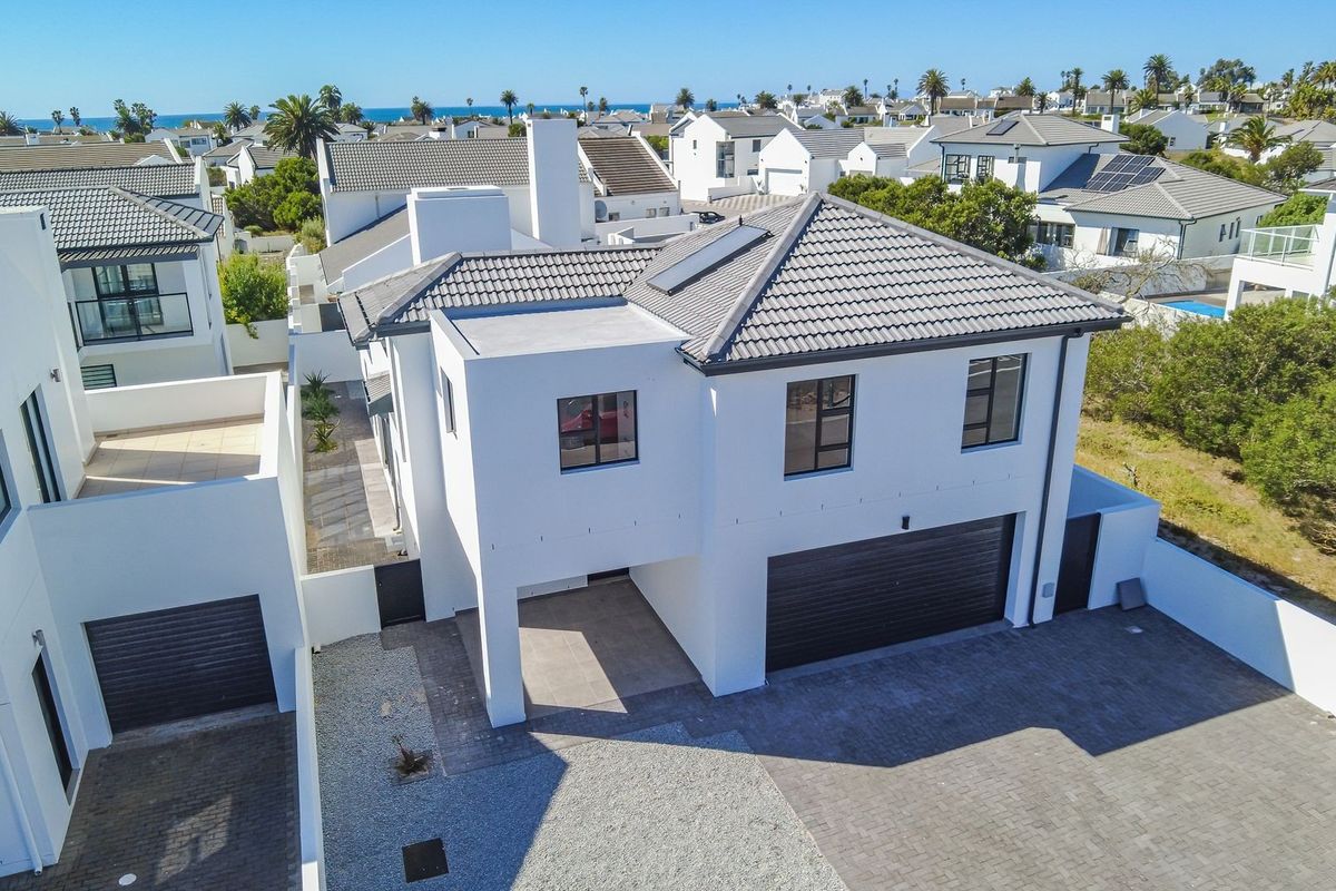 Aerial view of a modern two-story residential property featuring a tiled roof, solar panels, and a paved driveway with a double garage.