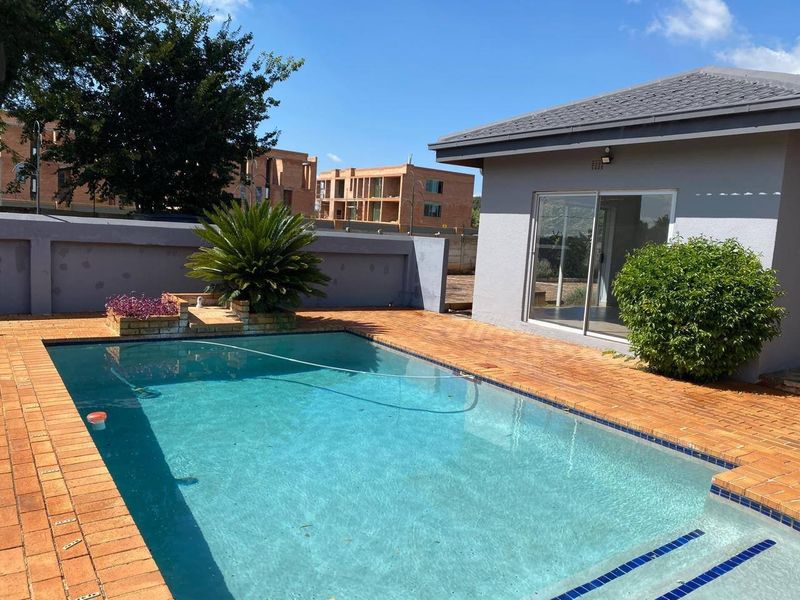 Outdoor pool area featuring a swimming pool, brick paved surround, and direct access to the home via a sliding glass door.