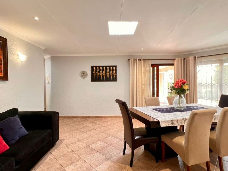 Spacious open-plan living and dining area featuring tiled flooring, recessed lighting, and direct access to the outdoor patio through sliding glass doors.