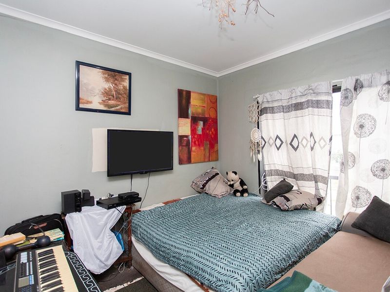 A bedroom featuring neutral wall tones, coving, and a sliding glass door providing natural light access.