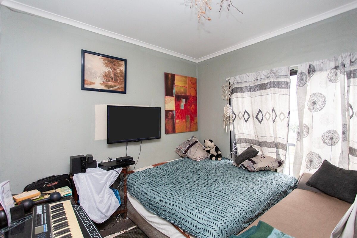A bedroom featuring neutral wall tones, coving, and a sliding glass door providing natural light access.