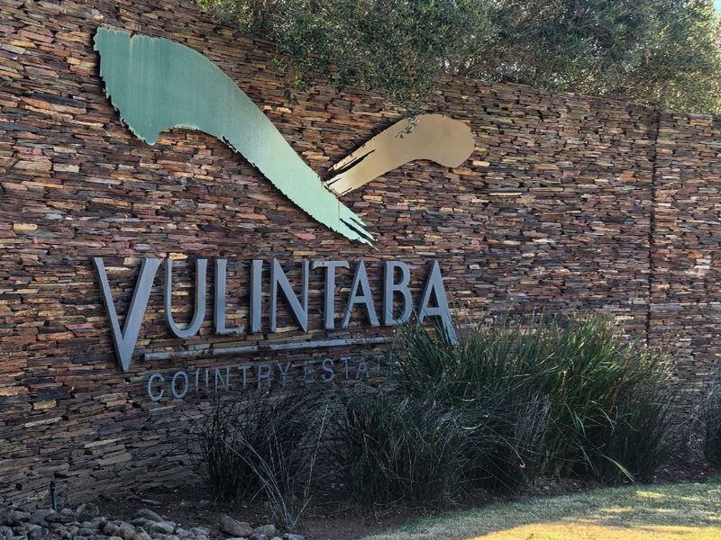Entrance signage wall for Vulintaba Country Estate featuring natural stone cladding and metal lettering.