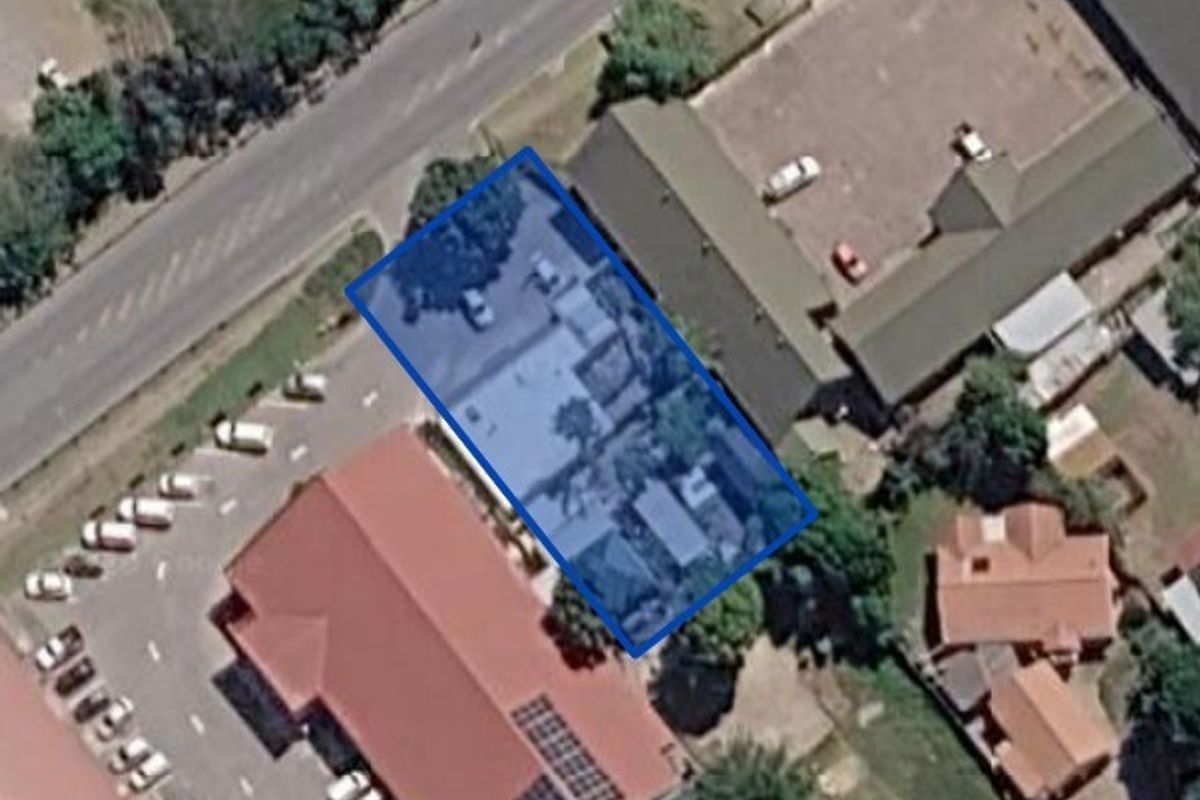An aerial view showing the property layout, including the building footprint and adjacent parking area.