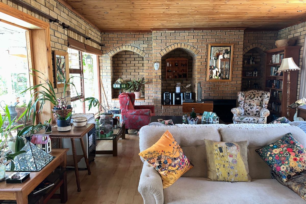 Spacious living room featuring exposed brick walls, timber ceiling, and built-in brick arched alcoves with a fireplace.