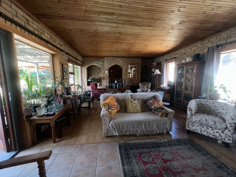 Spacious living room featuring exposed brick walls, a timber tongue and groove ceiling, and large sliding doors providing access to the outdoor area.