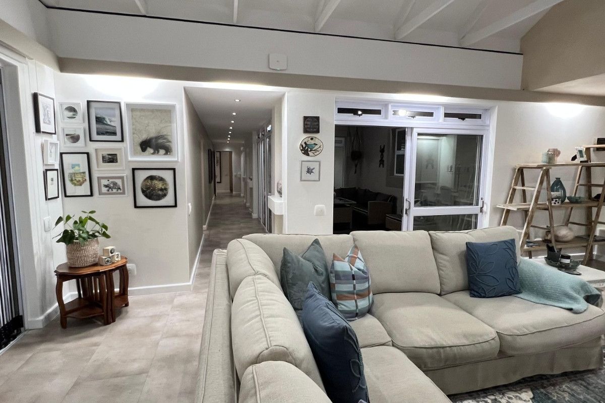 Spacious living area featuring a high vaulted ceiling, recessed lighting, and large sliding glass doors leading to an outdoor space.