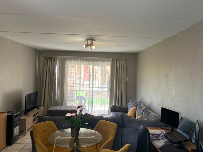 A functional living room featuring tiled flooring, a gas heater, and a sliding glass door providing access to the exterior.