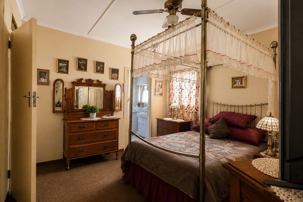 A carpeted bedroom featuring a ceiling fan and direct access to an adjoining bathroom.