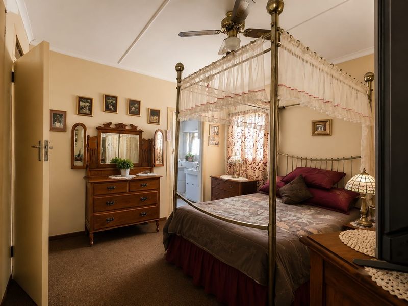 A carpeted bedroom featuring a ceiling fan and direct access to an adjoining bathroom.