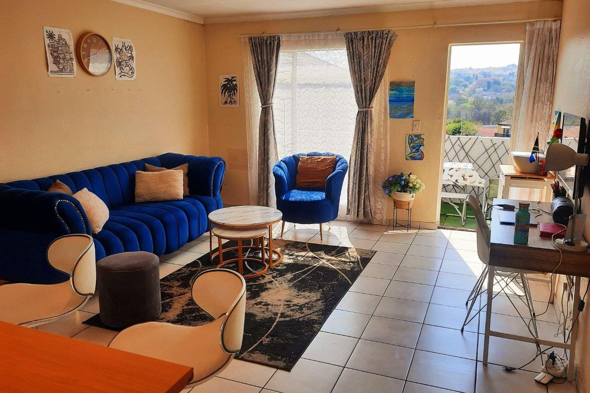 A bright living room featuring tiled flooring, recessed lighting, and direct access to an outdoor balcony area with scenic views.
