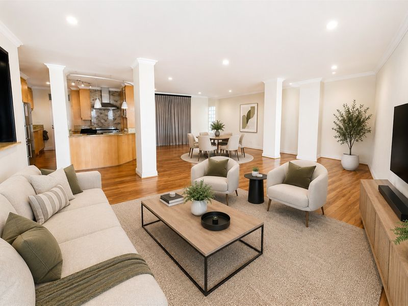 Spacious open-plan living and dining area featuring hardwood flooring, recessed lighting, and a well-appointed kitchen with integrated cabinetry.
