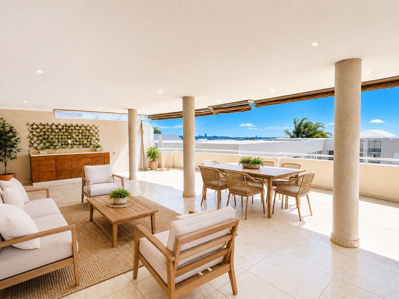 Spacious covered balcony featuring tiled flooring, recessed lighting, and structural columns, offering an open-air entertainment space with elevated views.
