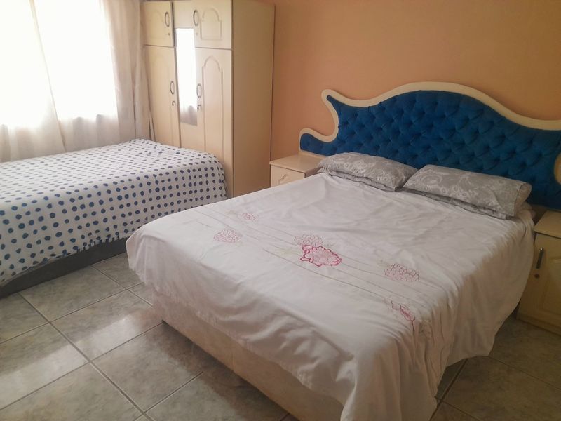 A bedroom featuring tiled flooring and neutral wall finishes, providing a functional space for rest.