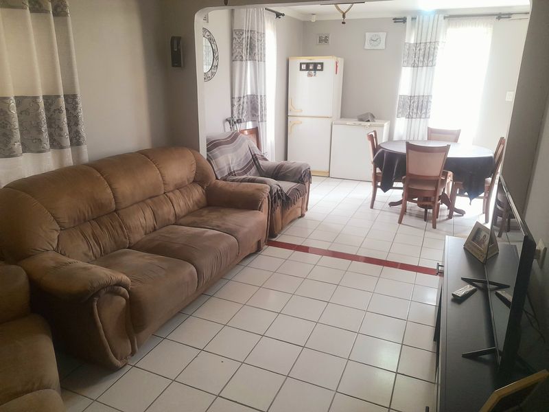 Open plan living and dining area featuring tiled flooring and a central archway connecting the spaces.