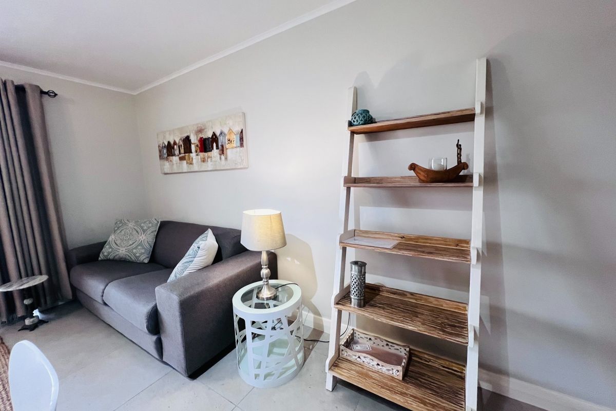 A well-maintained living room area featuring neutral tiled flooring and clean wall finishes, providing a comfortable and functional space.