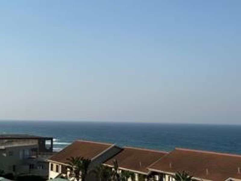A scenic elevated view overlooking the ocean and surrounding residential rooftops.