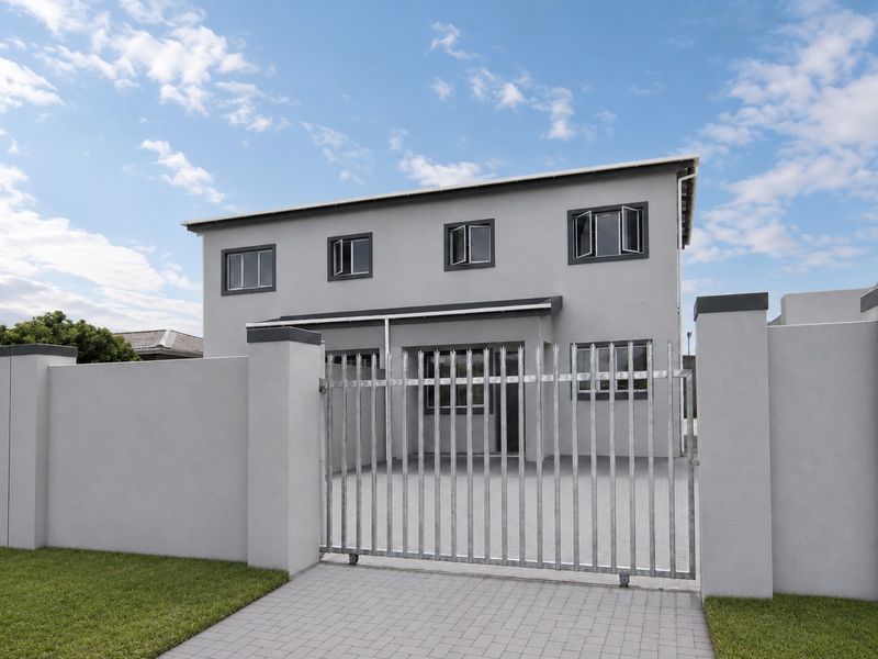 A modern two-story house exterior featuring a secure perimeter wall, sliding gate, paved driveway, and clean grey facade finishes.