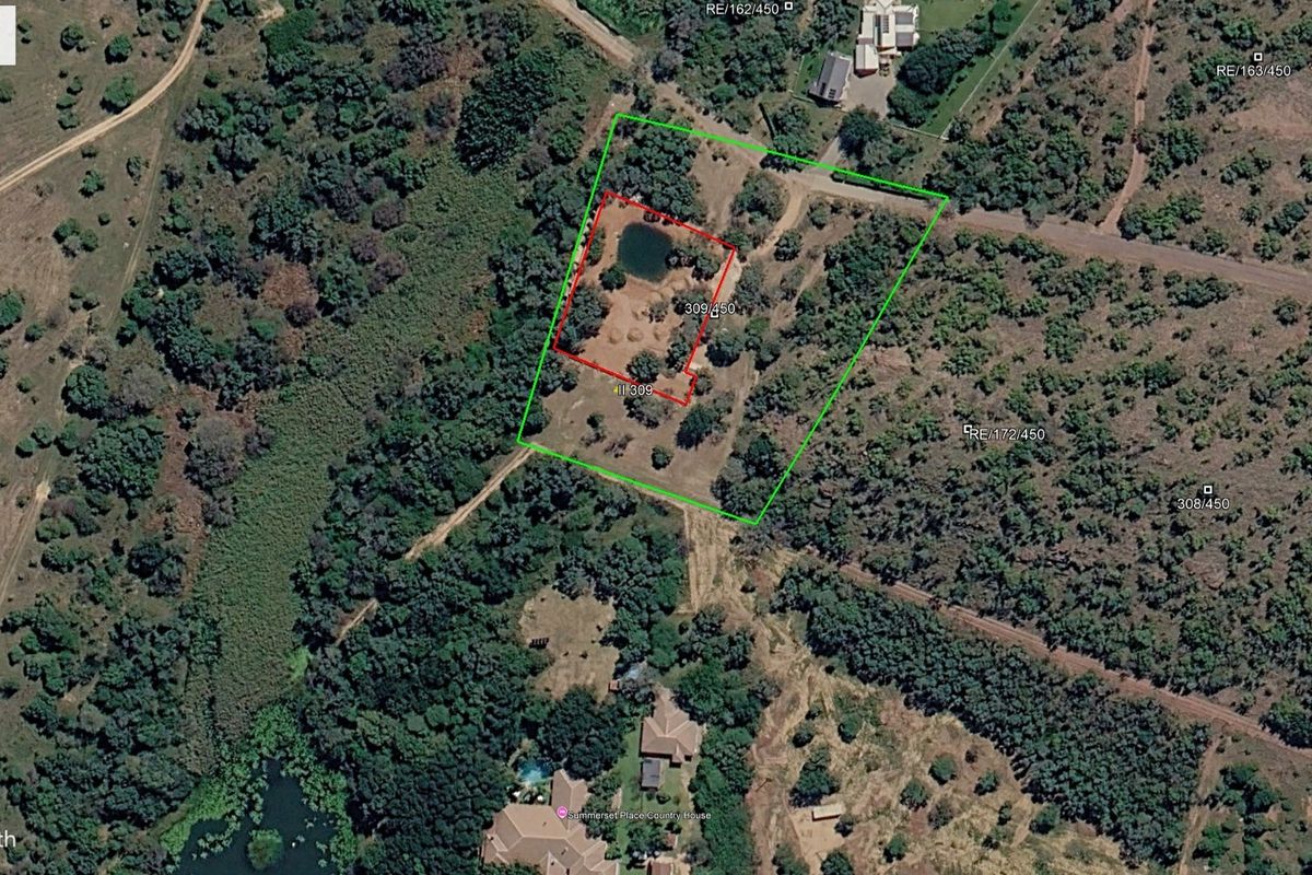 Aerial view of a vacant residential stand featuring natural vegetation and a small pond within the property boundaries.