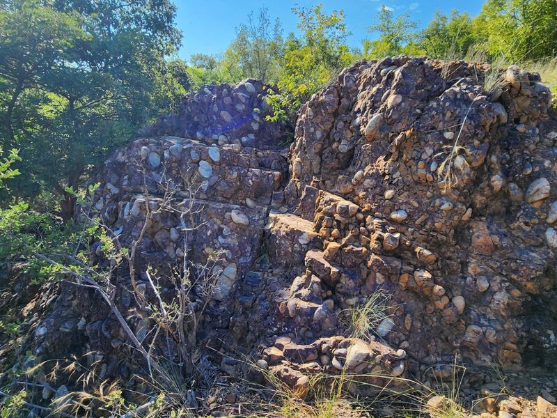 A natural rock formation featuring conglomerate stone set within the property's native landscape and vegetation.