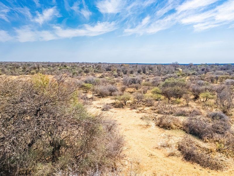 An aerial view of a large, undeveloped residential plot featuring native bushveld vegetation and open terrain.