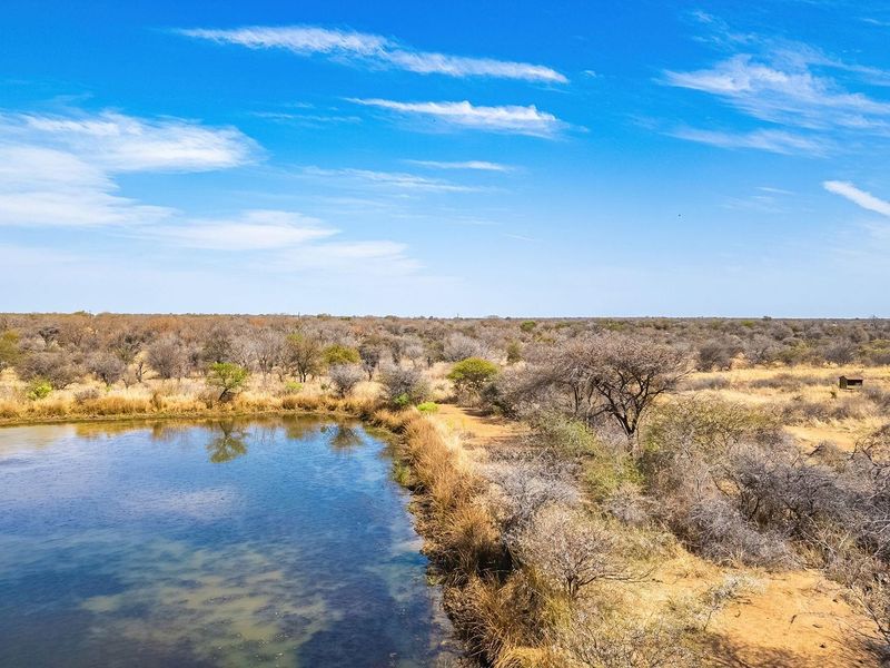 Aerial view of the vacant land featuring a natural dam and established indigenous bushveld vegetation.