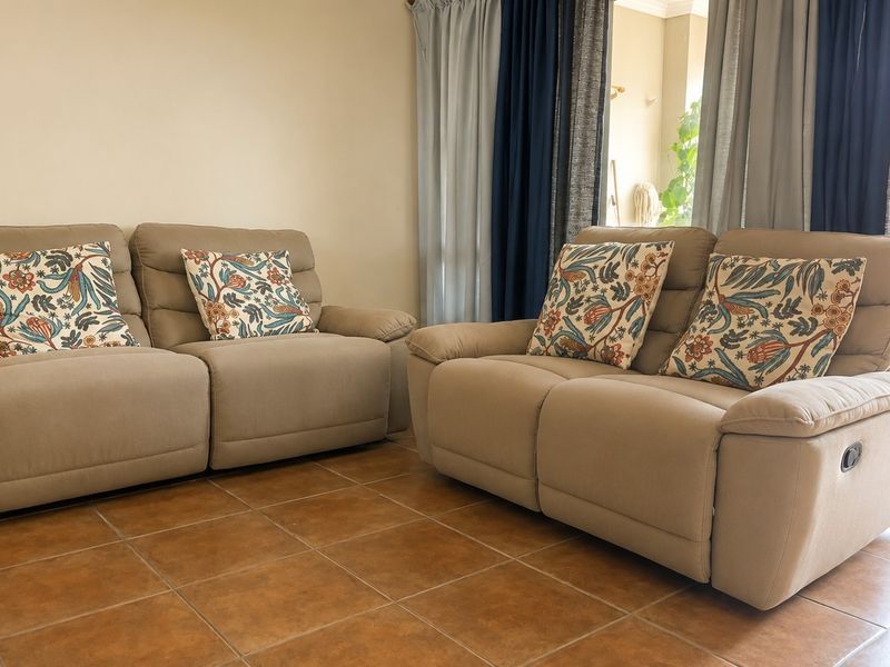 A living room area featuring ceramic tile flooring and a sliding glass door providing access to an outdoor space.