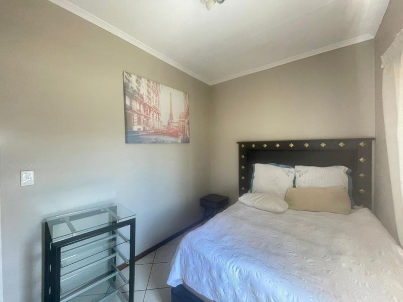 A standard bedroom featuring tiled flooring and neutral wall finishes, providing a functional and comfortable sleeping space.