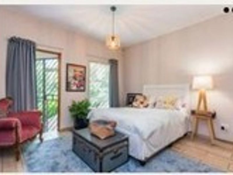 A bedroom featuring tiled flooring, a security gate leading to an outdoor area, and neutral wall finishes.