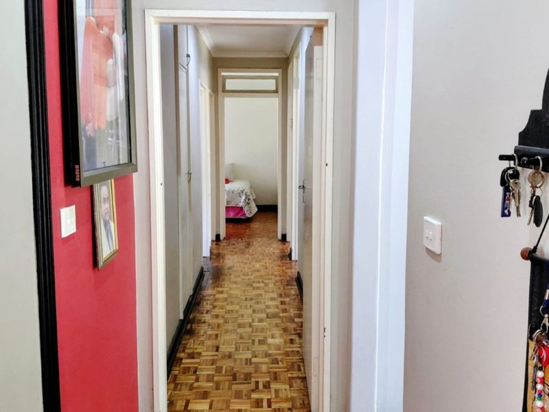 A functional hallway featuring classic parquet flooring and built-in storage, providing access to the various rooms within the home.