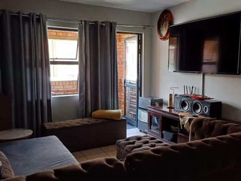 A living room featuring tiled flooring and a sliding door providing access to an outdoor area.
