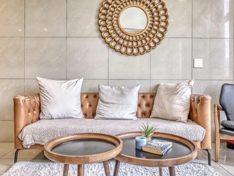 A modern living room area featuring large format polished wall tiles and a clean, contemporary aesthetic.