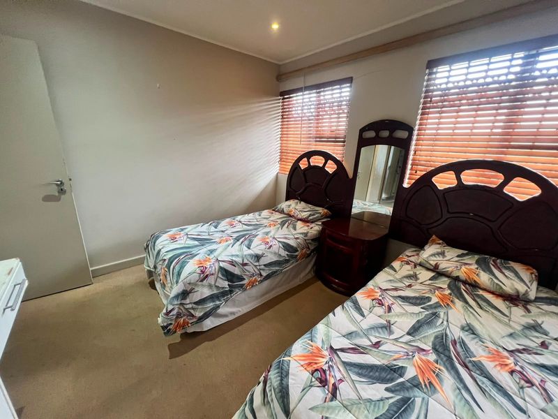 A bedroom featuring carpeted flooring, recessed ceiling lighting, and venetian blinds on the windows.