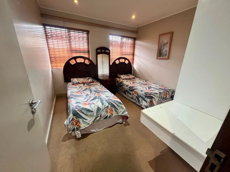A functional bedroom featuring carpeted flooring, recessed downlighting, and venetian blinds, offering a neutral space ready for modernization.
