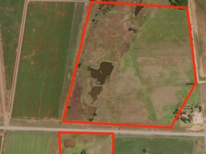 Aerial view of the farm property showing large agricultural land parcels, dams, and access roads outlined in red.