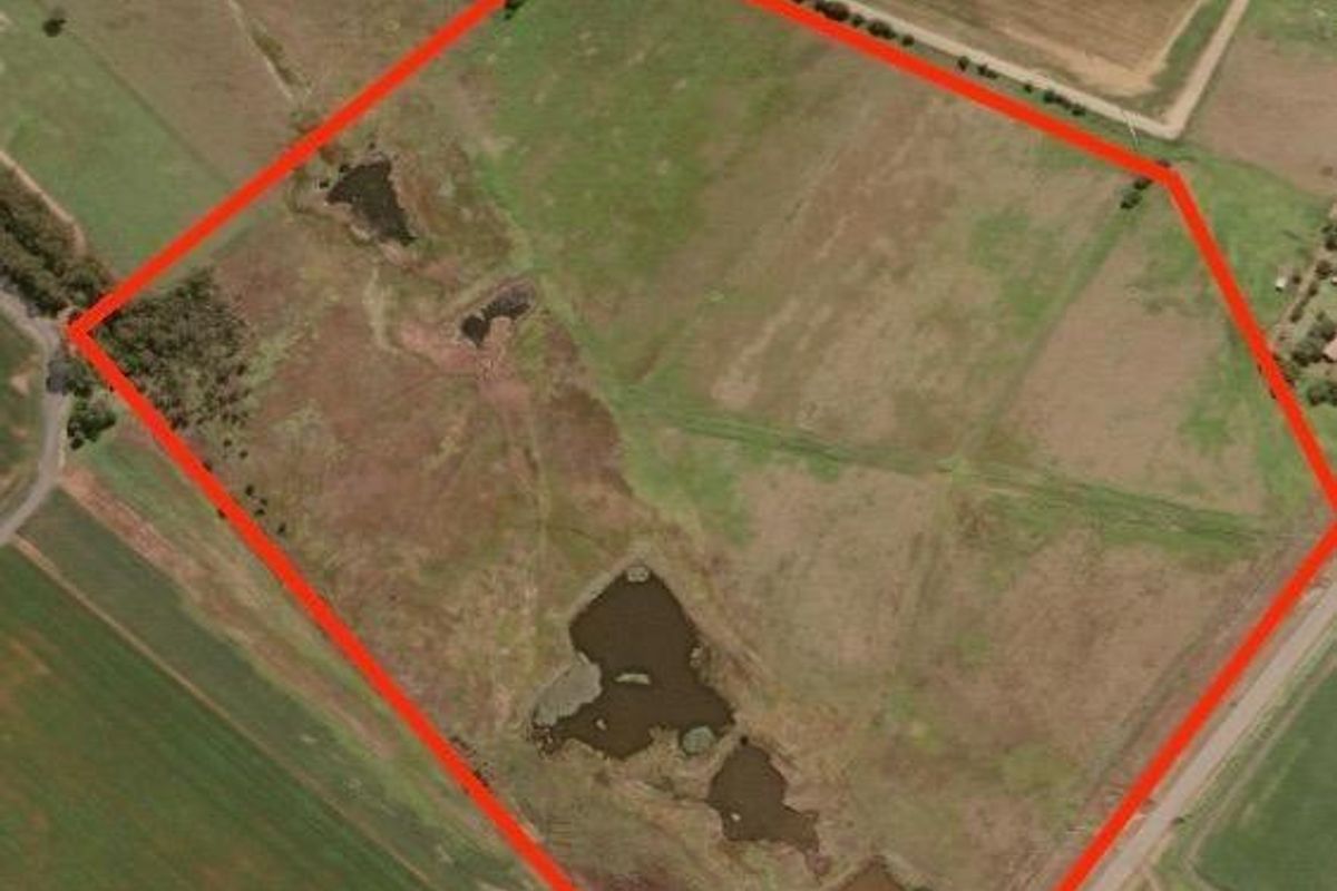 Aerial view of a large farm property featuring open pasture land, established fencing, and multiple natural dams.