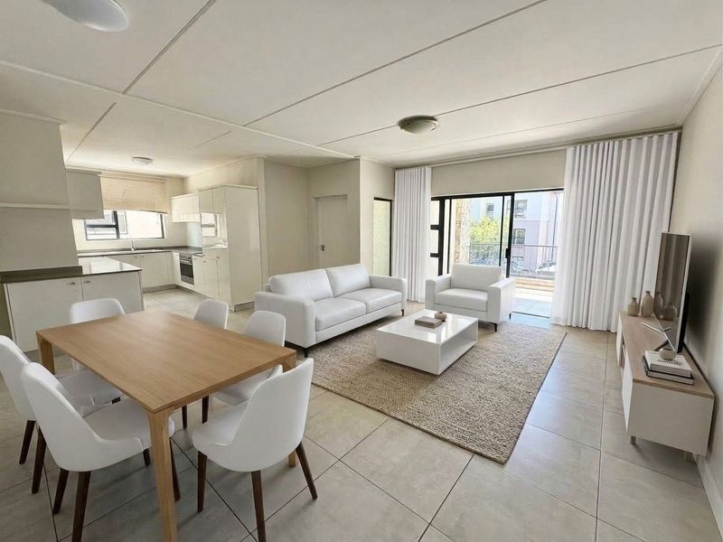Bright open-plan living and dining area featuring tiled floors, a modern kitchen with built-in cabinetry, and direct access to a private balcony.