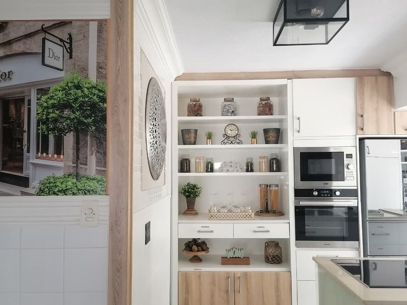 Modern kitchen featuring integrated cabinetry, built-in oven and microwave, and custom open shelving with a clean, contemporary finish.