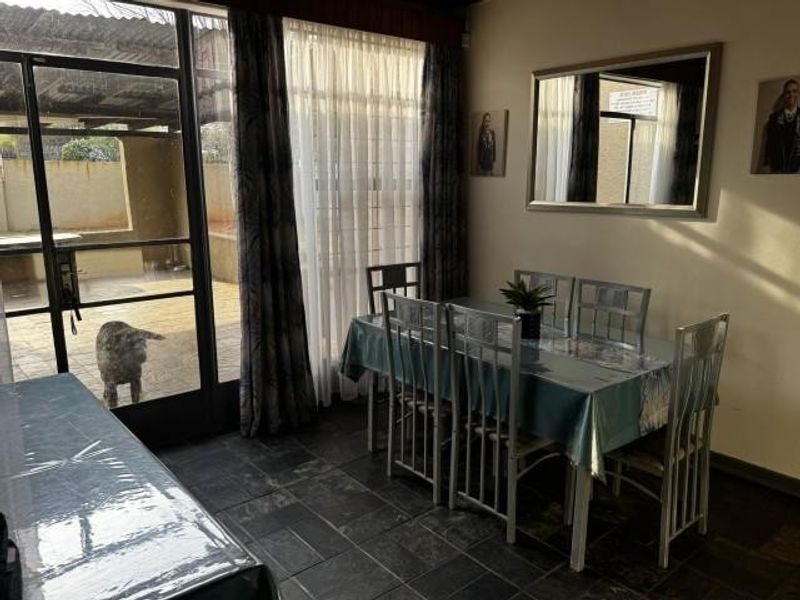 Dining area featuring slate tile flooring and direct access to the outdoor patio through a large sliding glass door.