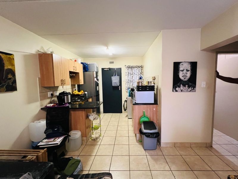 A functional kitchen area featuring built-in cabinetry, granite countertops, and tiled flooring, providing a practical layout for daily use.