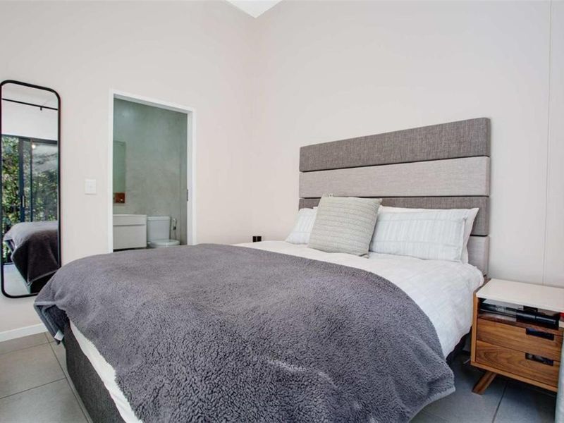 A well-maintained bedroom featuring tiled flooring and direct access to an en-suite bathroom.
