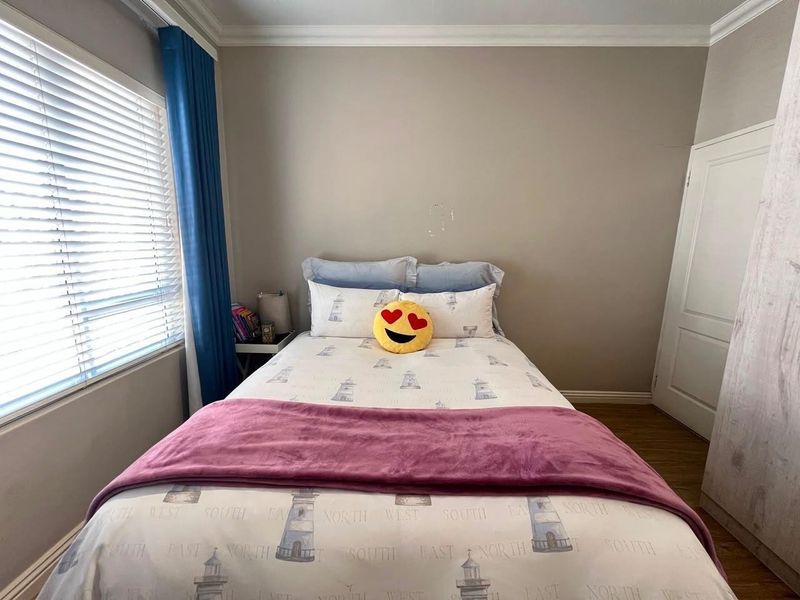 A functional bedroom featuring crown molding, skirting boards, and venetian blinds, providing a neutral base for personalization.