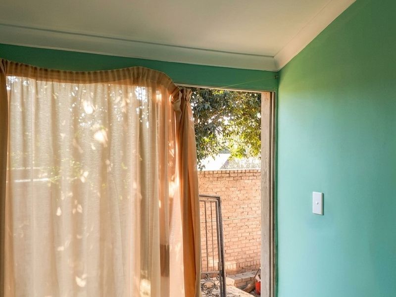 An interior entry area featuring a sliding door leading to an outdoor space, finished with painted walls and decorative ceiling cornicing.