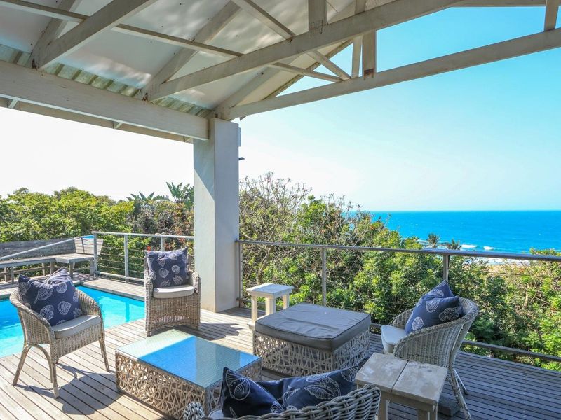 Spacious covered timber deck featuring a swimming pool and panoramic ocean views, providing an ideal outdoor entertainment area.