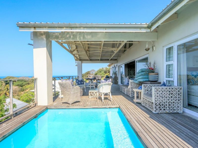 Spacious outdoor entertainment area featuring a swimming pool, timber decking, and a covered patio with direct access to the interior living spaces.