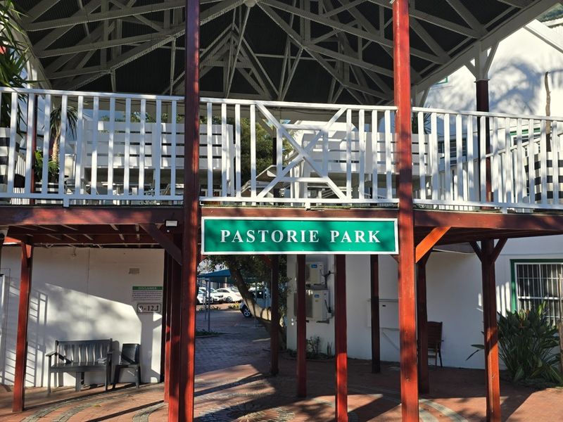 A view of the Pastorie Park entrance featuring a raised timber deck, exposed roof trusses, and a paved walkway.