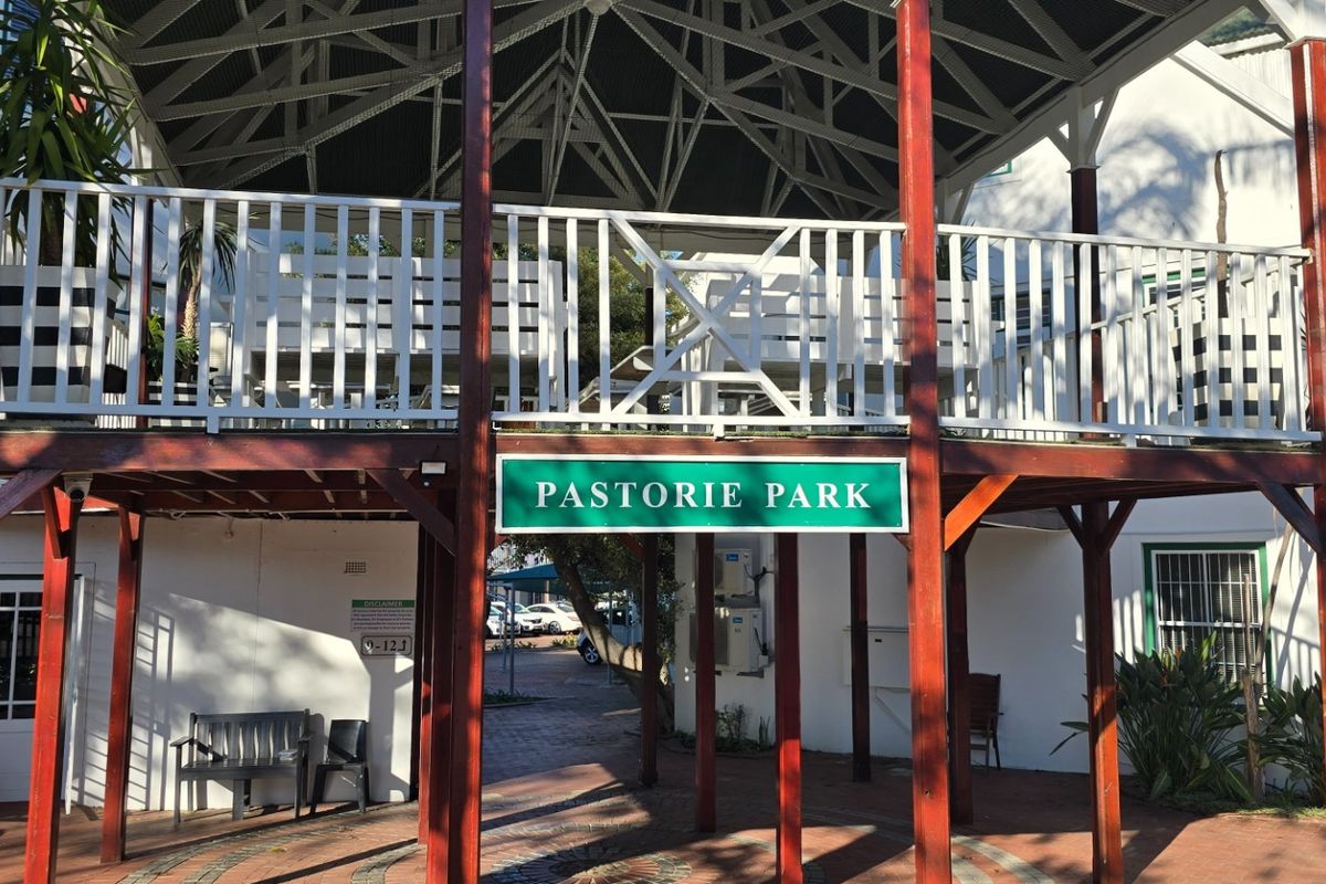 A view of the Pastorie Park entrance featuring a raised timber deck, exposed roof trusses, and a paved walkway.