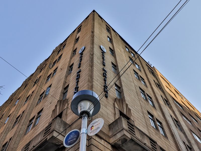 Low angle view of the Castle Mansions commercial building facade, showcasing its multi-story stone architecture and prominent corner signage.