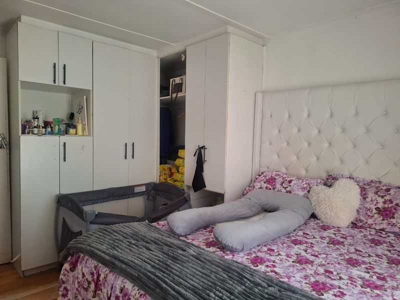 A bedroom featuring white built-in wardrobes providing ample storage space.