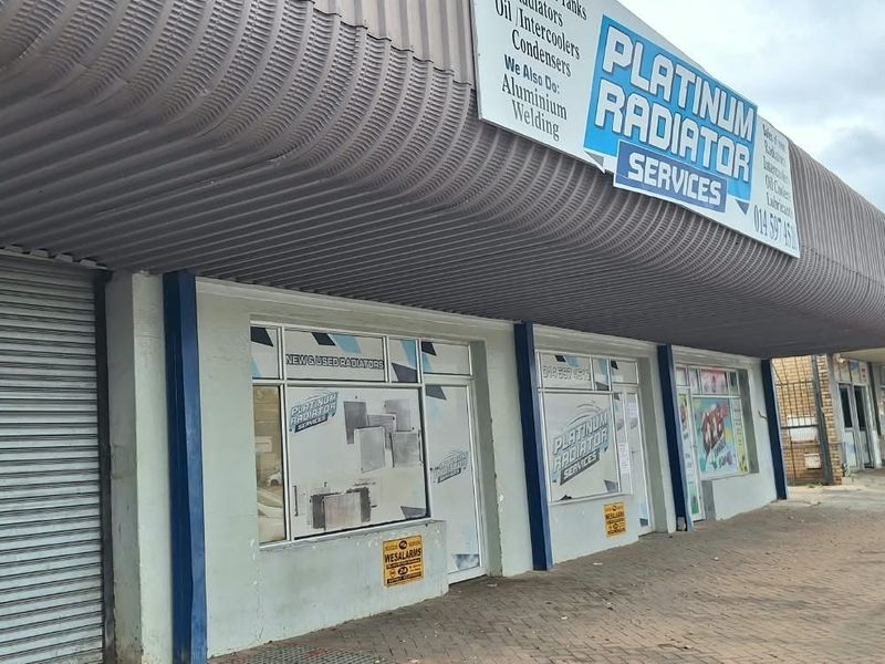 Commercial storefront featuring a large metal awning, roller shutter security, and prominent signage for a radiator service business.